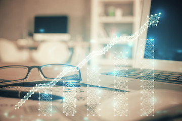 Financial chart hologram with glasses on the table background. Concept of business. Double exposure.
