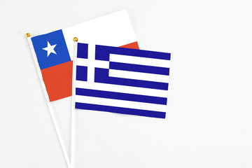 Greece and Chile stick flags on white background. High quality fabric, miniature national flag. Peaceful global concept.White floor for copy space.