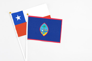 Guam and Chile stick flags on white background. High quality fabric, miniature national flag. Peaceful global concept.White floor for copy space.