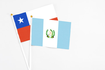 Guatemala and Chile stick flags on white background. High quality fabric, miniature national flag. Peaceful global concept.White floor for copy space.