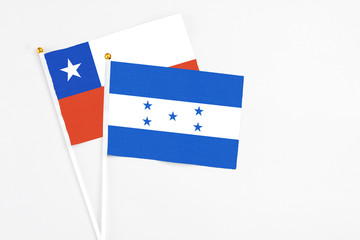Honduras and Chile stick flags on white background. High quality fabric, miniature national flag. Peaceful global concept.White floor for copy space.