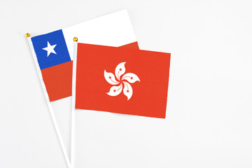 Hong Kong and Chile stick flags on white background. High quality fabric, miniature national flag. Peaceful global concept.White floor for copy space.