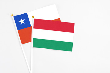 Hungary and Chile stick flags on white background. High quality fabric, miniature national flag. Peaceful global concept.White floor for copy space.