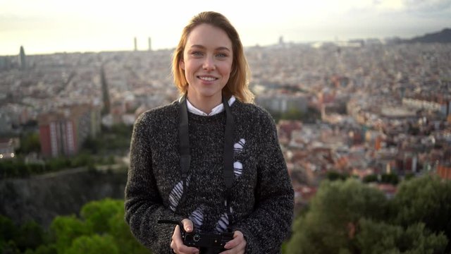 Portrait of female photographer with city in background