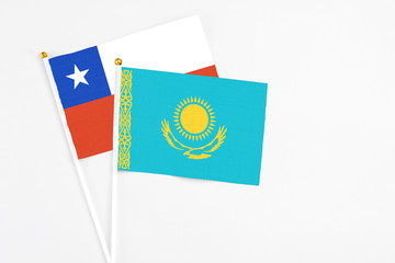 Kazakhstan and Chile stick flags on white background. High quality fabric, miniature national flag. Peaceful global concept.White floor for copy space.