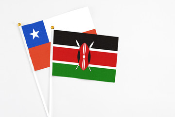 Kenya and Chile stick flags on white background. High quality fabric, miniature national flag. Peaceful global concept.White floor for copy space.