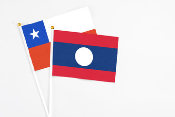 Laos and Chile stick flags on white background. High quality fabric, miniature national flag. Peaceful global concept.White floor for copy space.