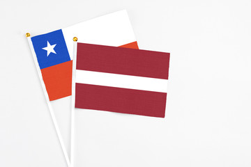 Latvia and Chile stick flags on white background. High quality fabric, miniature national flag. Peaceful global concept.White floor for copy space.
