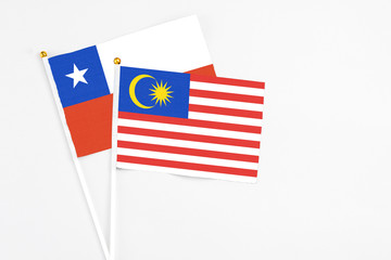 Malaysia and Chile stick flags on white background. High quality fabric, miniature national flag. Peaceful global concept.White floor for copy space.