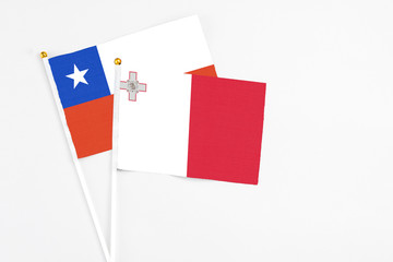Malta and Chile stick flags on white background. High quality fabric, miniature national flag. Peaceful global concept.White floor for copy space.