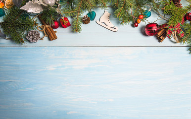 Christmas holiday background with fir branches and decorations on the blue paint wooden planks....