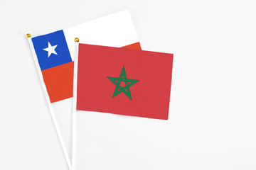 Morocco and Chile stick flags on white background. High quality fabric, miniature national flag. Peaceful global concept.White floor for copy space.