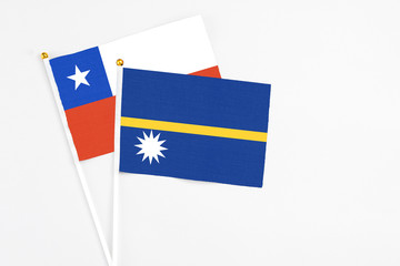 Nauru and Chile stick flags on white background. High quality fabric, miniature national flag. Peaceful global concept.White floor for copy space.