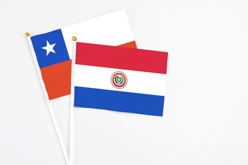 Paraguay and Chile stick flags on white background. High quality fabric, miniature national flag. Peaceful global concept.White floor for copy space.