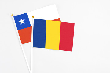 Romania and Chile stick flags on white background. High quality fabric, miniature national flag. Peaceful global concept.White floor for copy space.