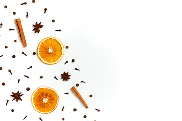 Christmas composition made of dried orange, cinnamon, black pepper, star anice and clove on white background. Top view, copy space. Set of spices for mulled wine.