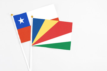 Seychelles and Chile stick flags on white background. High quality fabric, miniature national flag. Peaceful global concept.White floor for copy space.