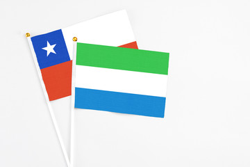 Sierra Leone and Chile stick flags on white background. High quality fabric, miniature national flag. Peaceful global concept.White floor for copy space.