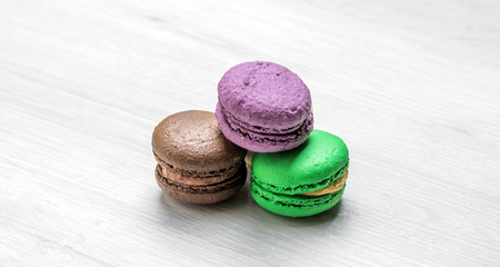 Sweet and colourful french macaroons or macaron on a bright wooden surface