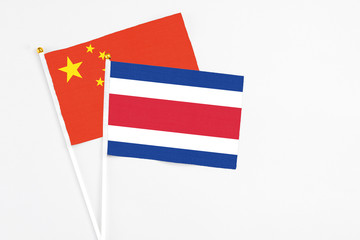 Costa Rica and China stick flags on white background. High quality fabric, miniature national flag. Peaceful global concept.White floor for copy space.