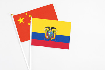 Ecuador and China stick flags on white background. High quality fabric, miniature national flag. Peaceful global concept.White floor for copy space.