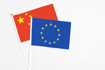 European Union and China stick flags on white background. High quality fabric, miniature national flag. Peaceful global concept.White floor for copy space.