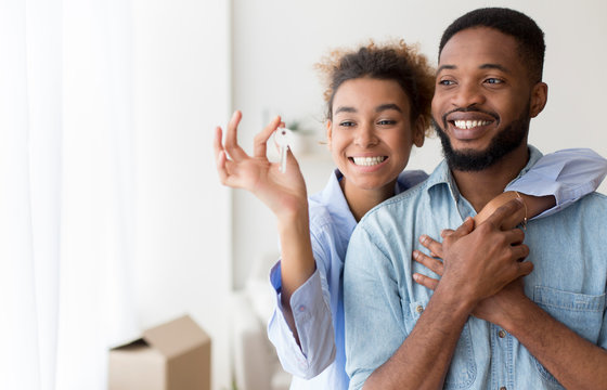 African American Couple Holding Key Embracing Standing In New Flat