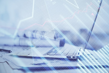 Stock market graph on background with desk and personal computer. Double exposure. Concept of financial analysis.