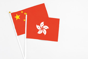 Hong Kong and China stick flags on white background. High quality fabric, miniature national flag. Peaceful global concept.White floor for copy space.