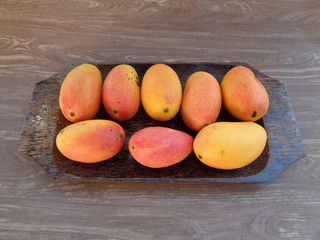 red mango, pelem podang suluh. podang mango ripe on the tree. indonesian exotic fruit with wooden tray