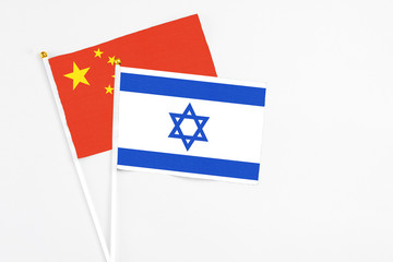 Israel and China stick flags on white background. High quality fabric, miniature national flag. Peaceful global concept.White floor for copy space.