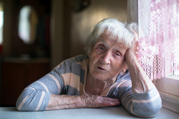 Portrait of a pensioner woman at the table in home.