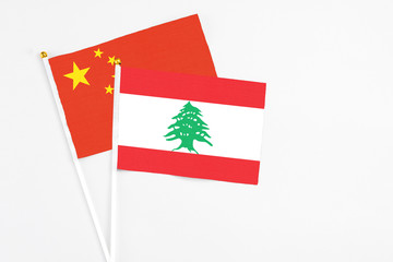 Lebanon and China stick flags on white background. High quality fabric, miniature national flag....