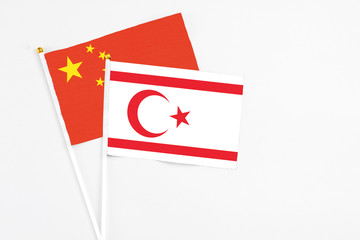 Northern Cyprus and China stick flags on white background. High quality fabric, miniature national flag. Peaceful global concept.White floor for copy space.