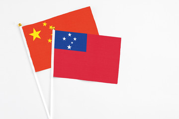 Samoa and China stick flags on white background. High quality fabric, miniature national flag. Peaceful global concept.White floor for copy space.