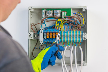 with the help of wire cutters, the master places the wire in the socket. panel board. not only electricity and internet control are mantled into it.