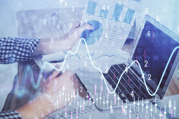 Double exposure of businessman with laptop and stock market forex chart.
