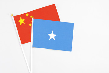 Somalia and China stick flags on white background. High quality fabric, miniature national flag. Peaceful global concept.White floor for copy space.