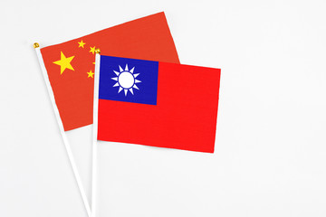 Taiwan and China stick flags on white background. High quality fabric, miniature national flag. Peaceful global concept.White floor for copy space.