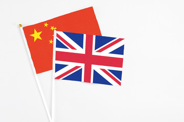 United Kingdom and China stick flags on white background. High quality fabric, miniature national flag. Peaceful global concept.White floor for copy space.
