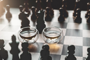 Still life two cups of green tea on chess board with warm tone, Homely and Cosy scene for Autumn and winter background