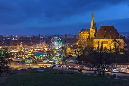 Erfurt, Germany. Christmas market on Domplatz (Cathedral Square) at the foot of Domberg (Cathedral Hill) with St Mary's Cathedral and Church of St Severus in dusk. View from Petersberg hill. 