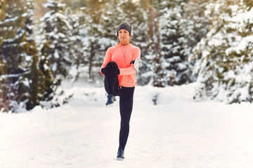 Woman does a warm-up in the snow in winter.