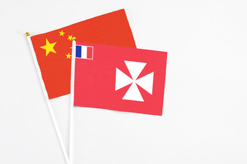 Wallis And Futuna and China stick flags on white background. High quality fabric, miniature national flag. Peaceful global concept.White floor for copy space.