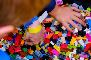 Children's hands reach for parts to play constructor