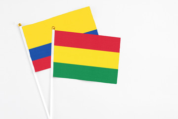 Bolivia and Colombia stick flags on white background. High quality fabric, miniature national flag. Peaceful global concept.White floor for copy space.