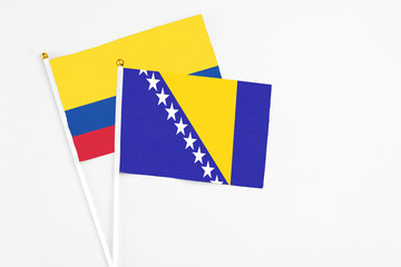 Bosnia Herzegovina and Colombia stick flags on white background. High quality fabric, miniature...