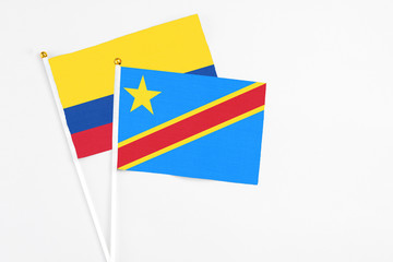 Congo and Colombia stick flags on white background. High quality fabric, miniature national flag. Peaceful global concept.White floor for copy space.