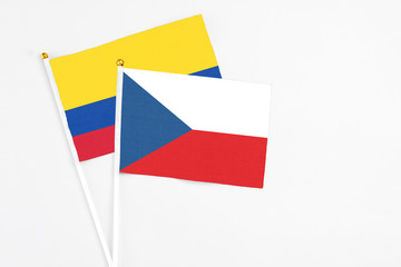 Czech Republic and Colombia stick flags on white background. High quality fabric, miniature national flag. Peaceful global concept.White floor for copy space.