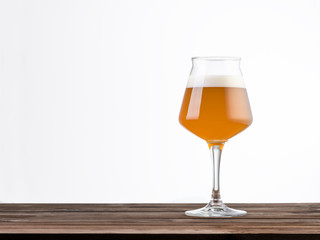 glass of beer over a wood table isolated on white background – Horizontal composition with copy space at the left